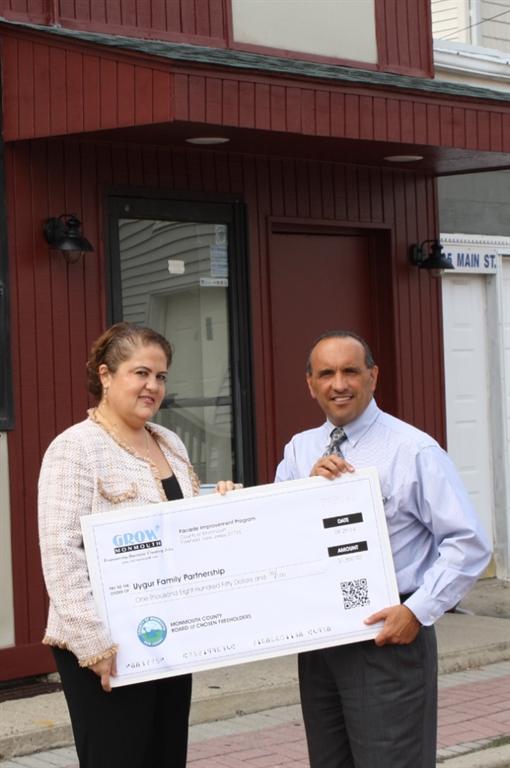 Sedef Piker, whose family owns the Uygur Family Partnership, accepts a $1,845 Façade Improvement Program reimbursement check from Freeholder Thomas A. Arnone on Sept. 29 in Eatontown, NJ.